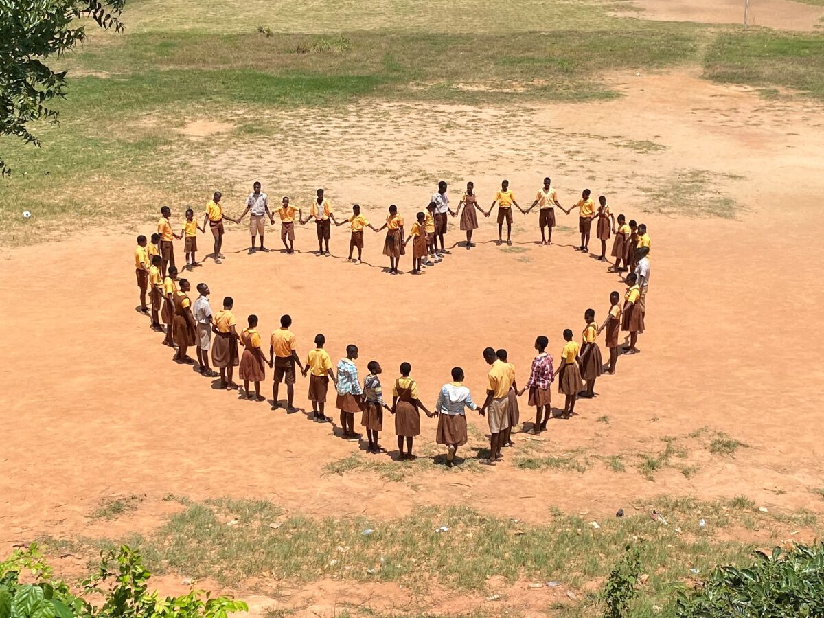 Luchtfoto van kinderen die een hart vormen door elkaars hand vast te houden Luchtfoto van kinderen die een hart vormen door elkaars hand vast te houden