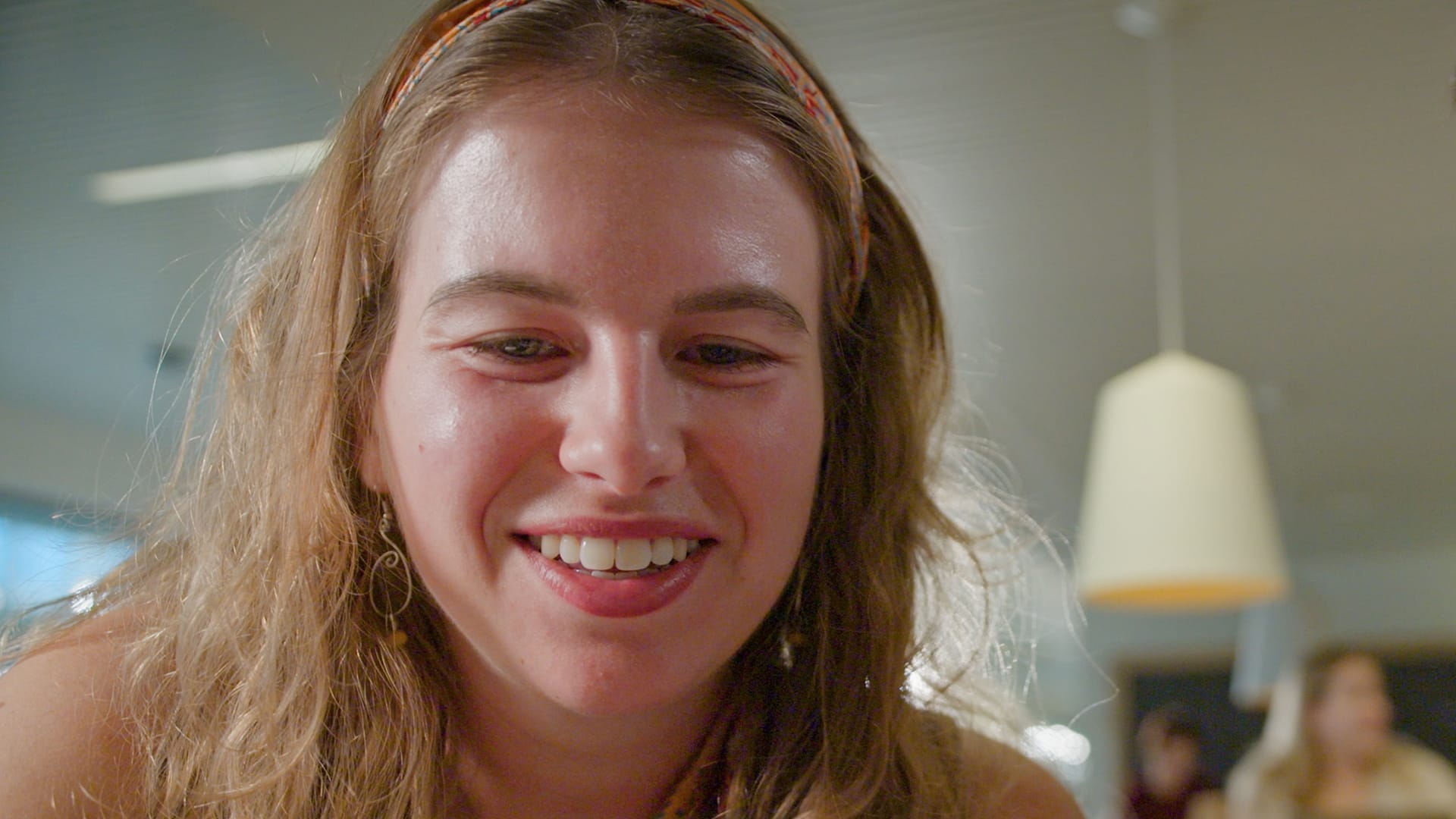 Een closeup van Hanne. Ze kijkt naar haar telefoonscherm, dit zich buiten beeld bevindt. Een closeup van Hanne. Ze kijkt naar haar telefoonscherm, dit zich buiten beeld bevindt.