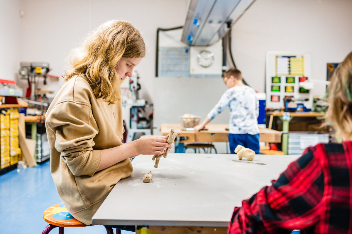 Meisje werkt met klei in een klaslokaal. Meisje werkt met klei in een klaslokaal.