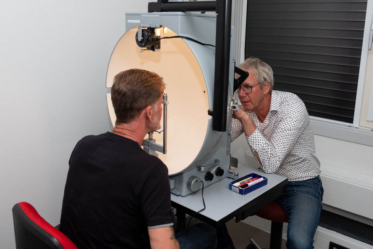 Cliënt en optometrist tijdens het visueel functieonderzoek Cliënt en optometrist tijdens het visueel functieonderzoek