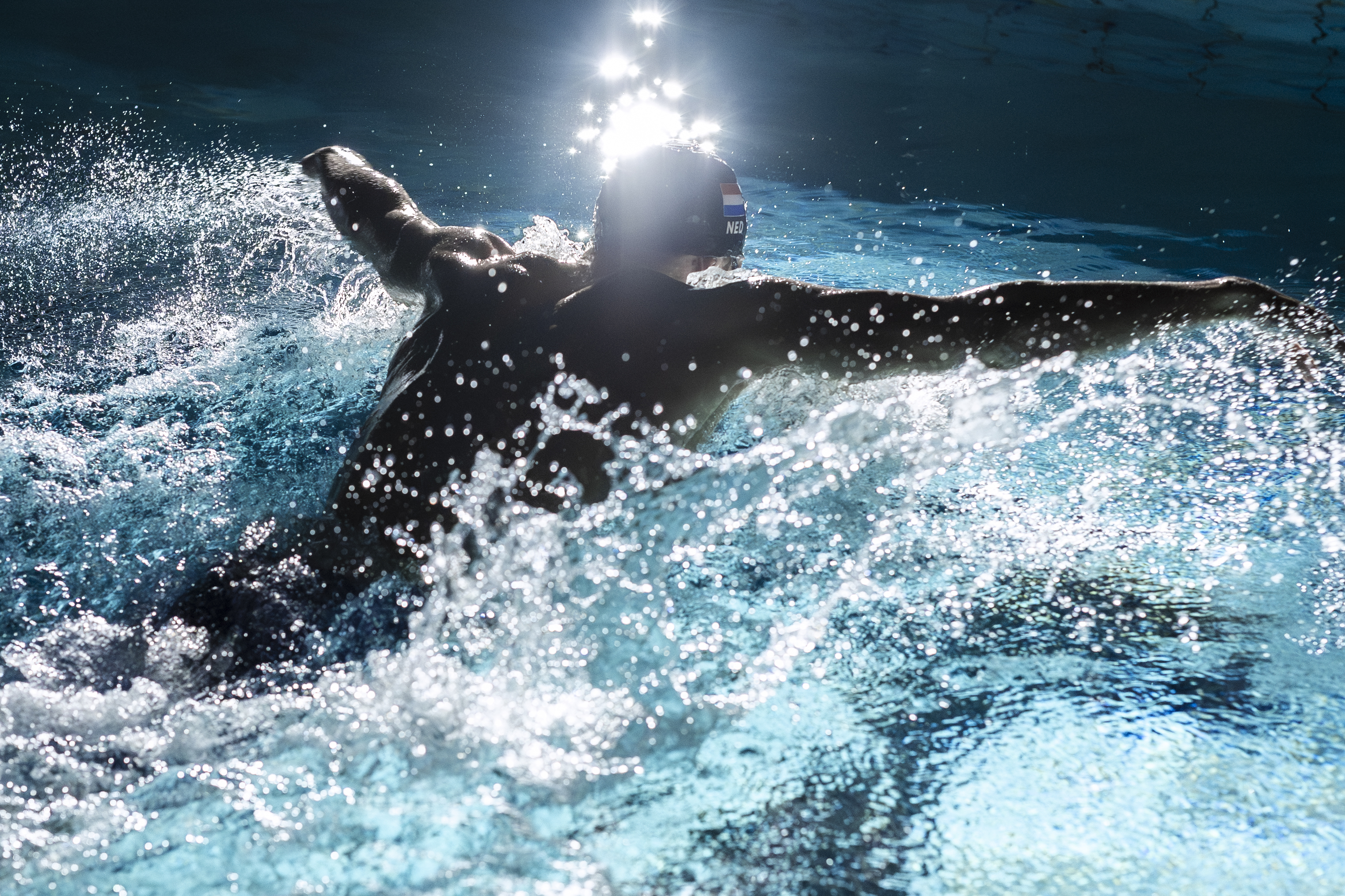 Rogier Dorsman doet de vlinderslag in een donker zwembad