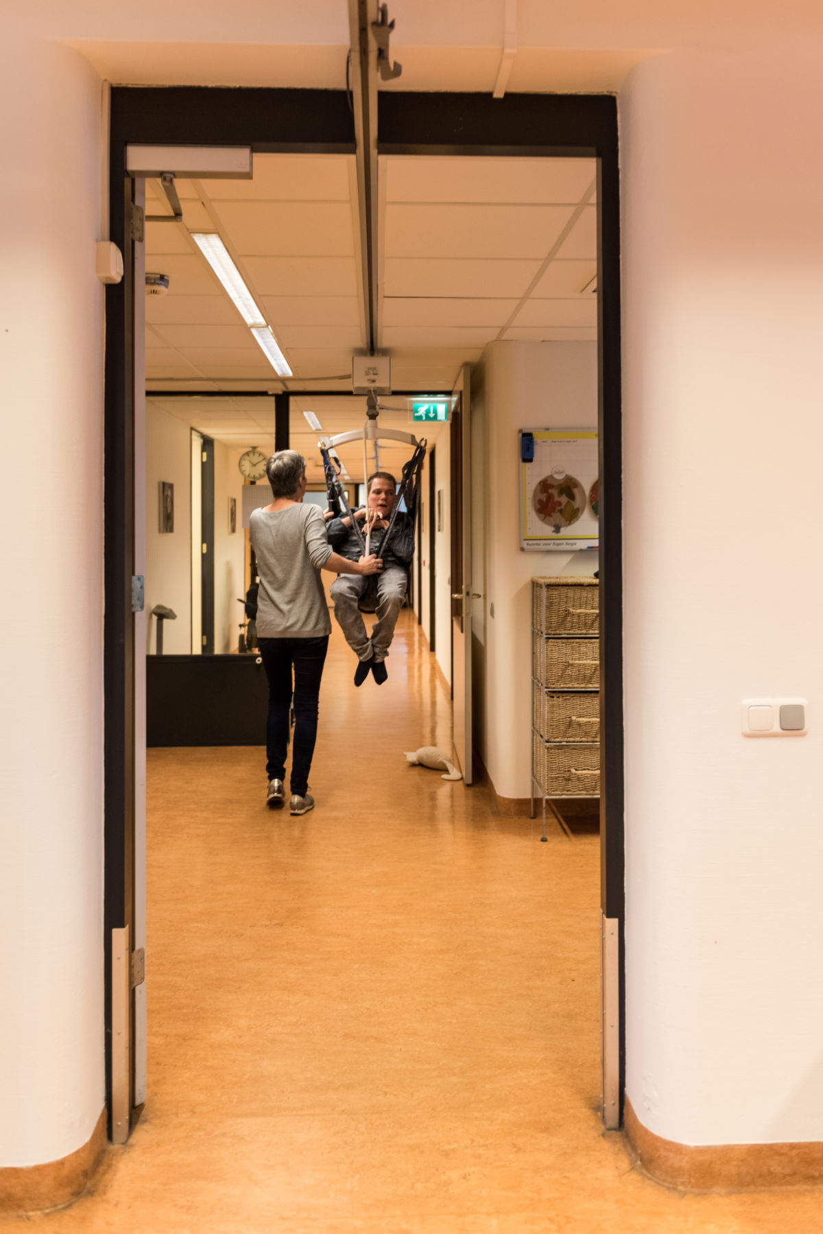 Begeleider ondersteunt cliënt in tillift bij Visio Wonen & Dagbesteding Emmen Begeleider ondersteunt cliënt in tillift bij Visio Wonen & Dagbesteding Emmen