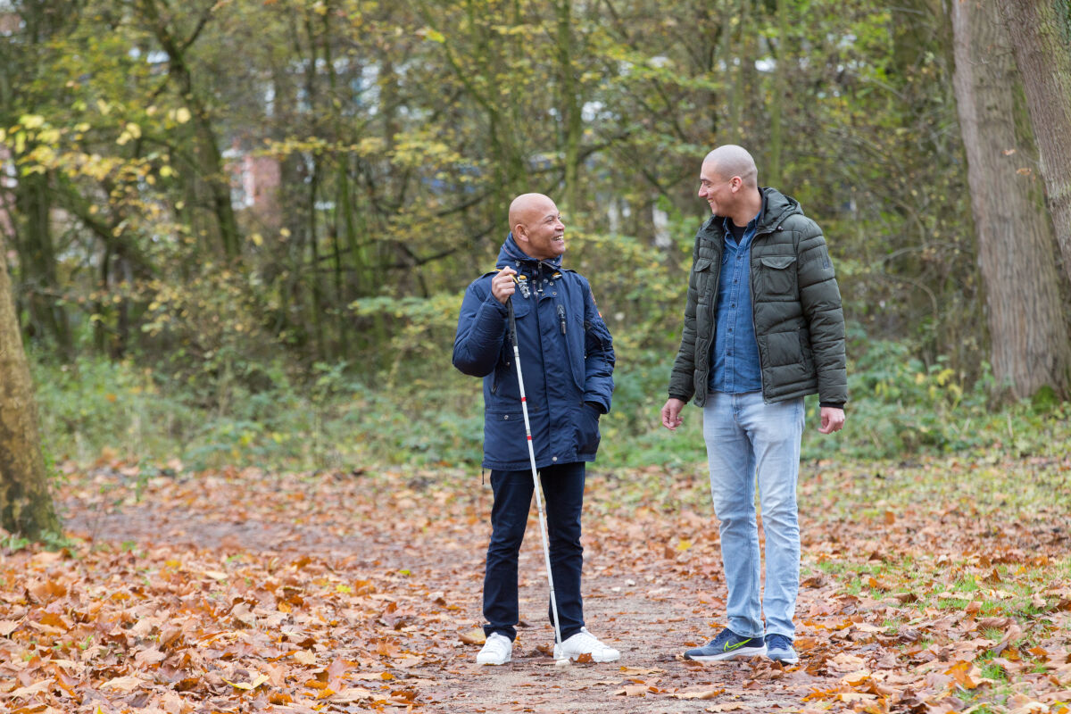 Cliënt loopt samen met ambulant specialistisch begeleider door het bos. Cliënt loopt samen met ambulant specialistisch begeleider door het bos.