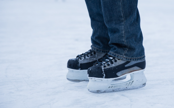 Op het ijs met schaatsen aan.