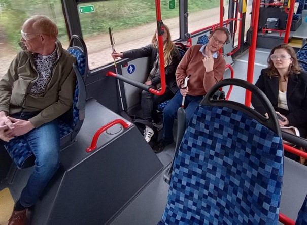 Vier mensen zitten in de bus