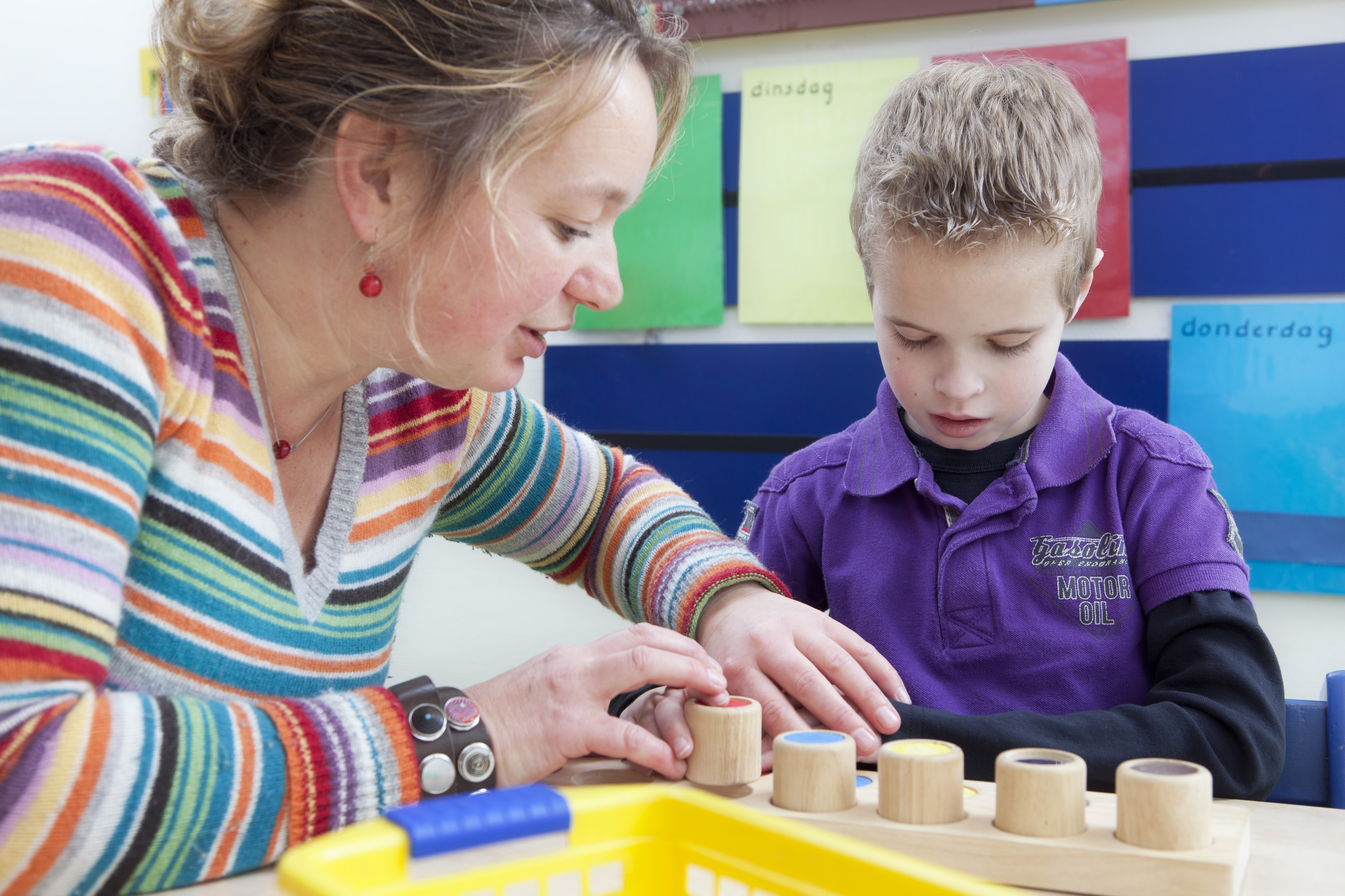 Begeleider helpt leerling met blokken spelen. Begeleider helpt leerling met blokken spelen.