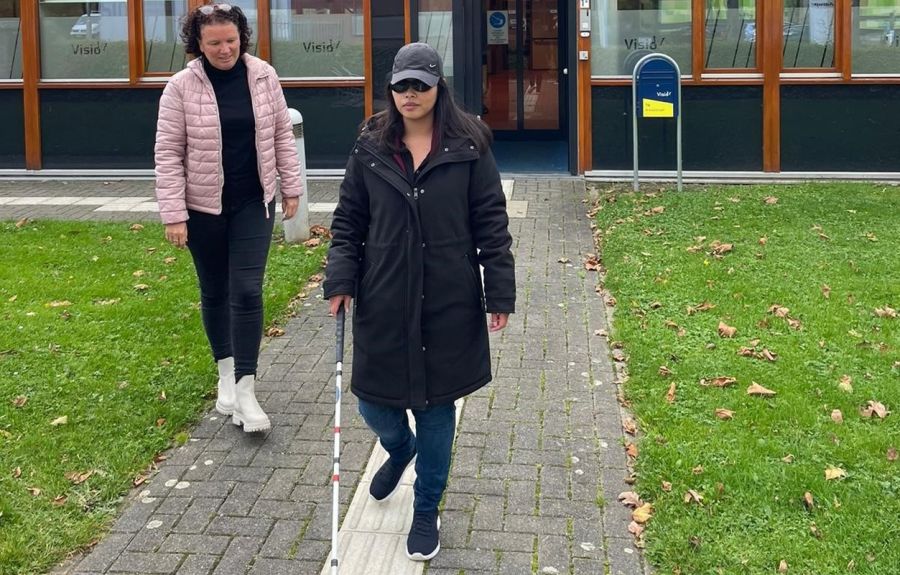 visio-het-loo-erf-Athittiya-Auaychai-loopt-met-stok-begeleid-door-medewerkerk.jpg (1) visio-het-loo-erf-Athittiya-Auaychai-loopt-met-stok-begeleid-door-medewerkerk.jpg (1)