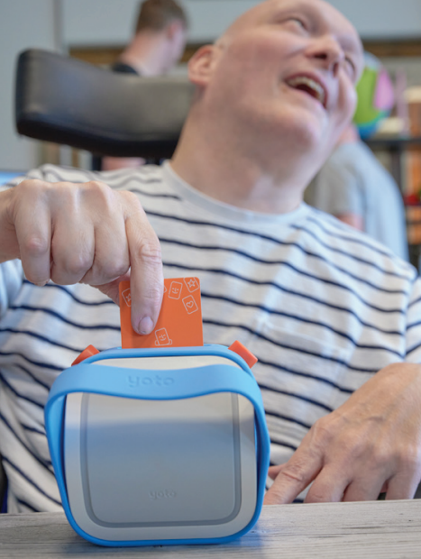 Een man stopt een pasje in de Yoto-muziekspeler. Een man stopt een pasje in de Yoto-muziekspeler.