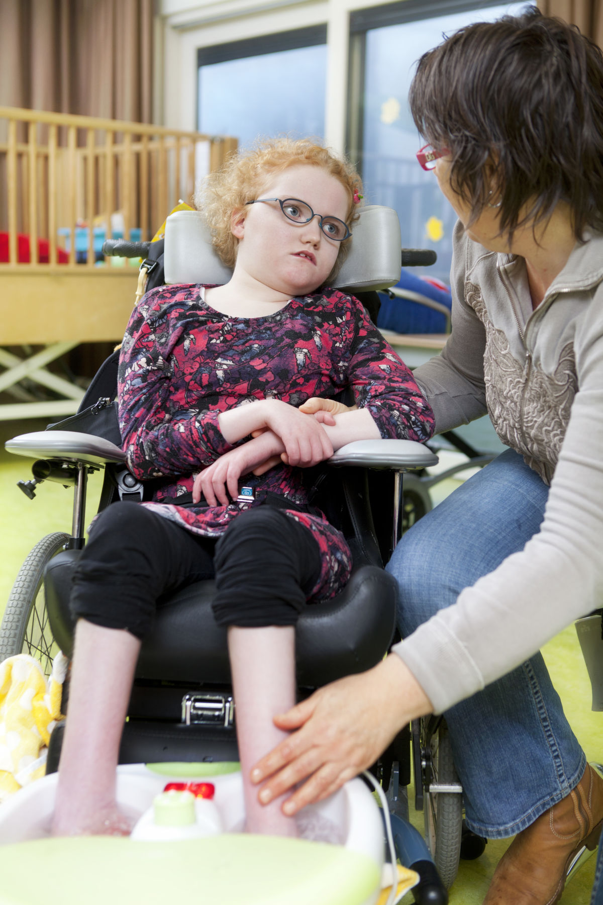 Meisje in rolstoel geniet van een voetenbadje onder begeleiding van een Visio-medewerker Visio-Haren-kind-jeugd-De-Heukelom-vvb-voetenbadje.jpg
