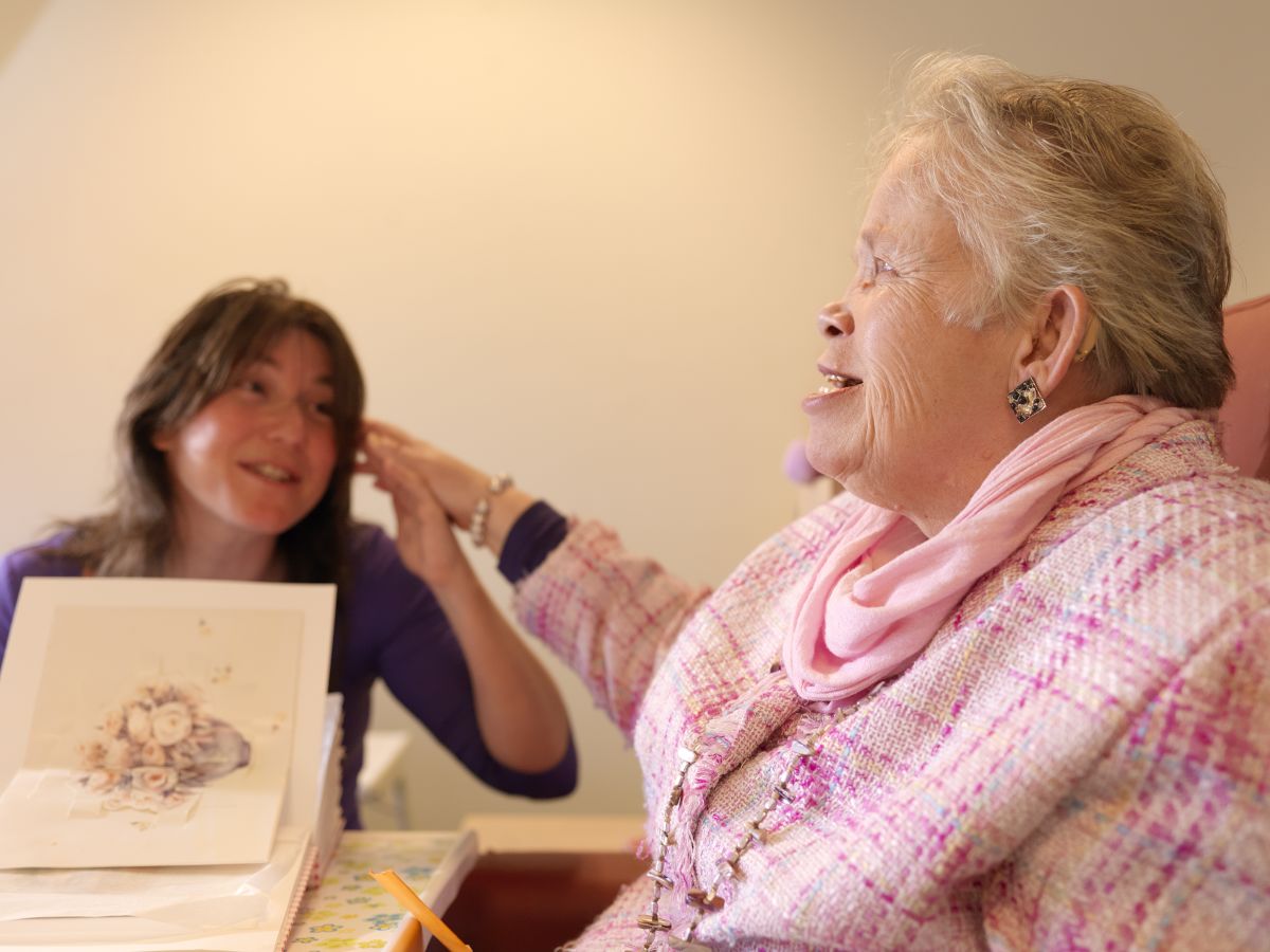 Oudere dame met visuele en verstandelijke beperking en een medewerker Oudere dame met visuele en verstandelijke beperking en een medewerker