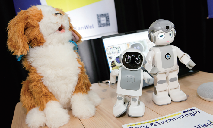 Een robothondje, en twee kleine robots staan op de afbeelding. Een robothondje, en twee kleine robots staan op de afbeelding.