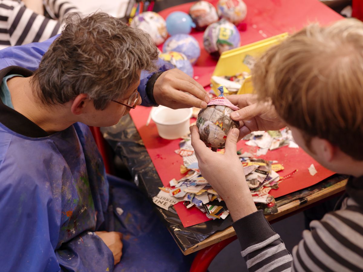 Twee mensen zijn samen creatief bezig met papier mache. Twee mensen zijn samen creatief bezig met papier mache.