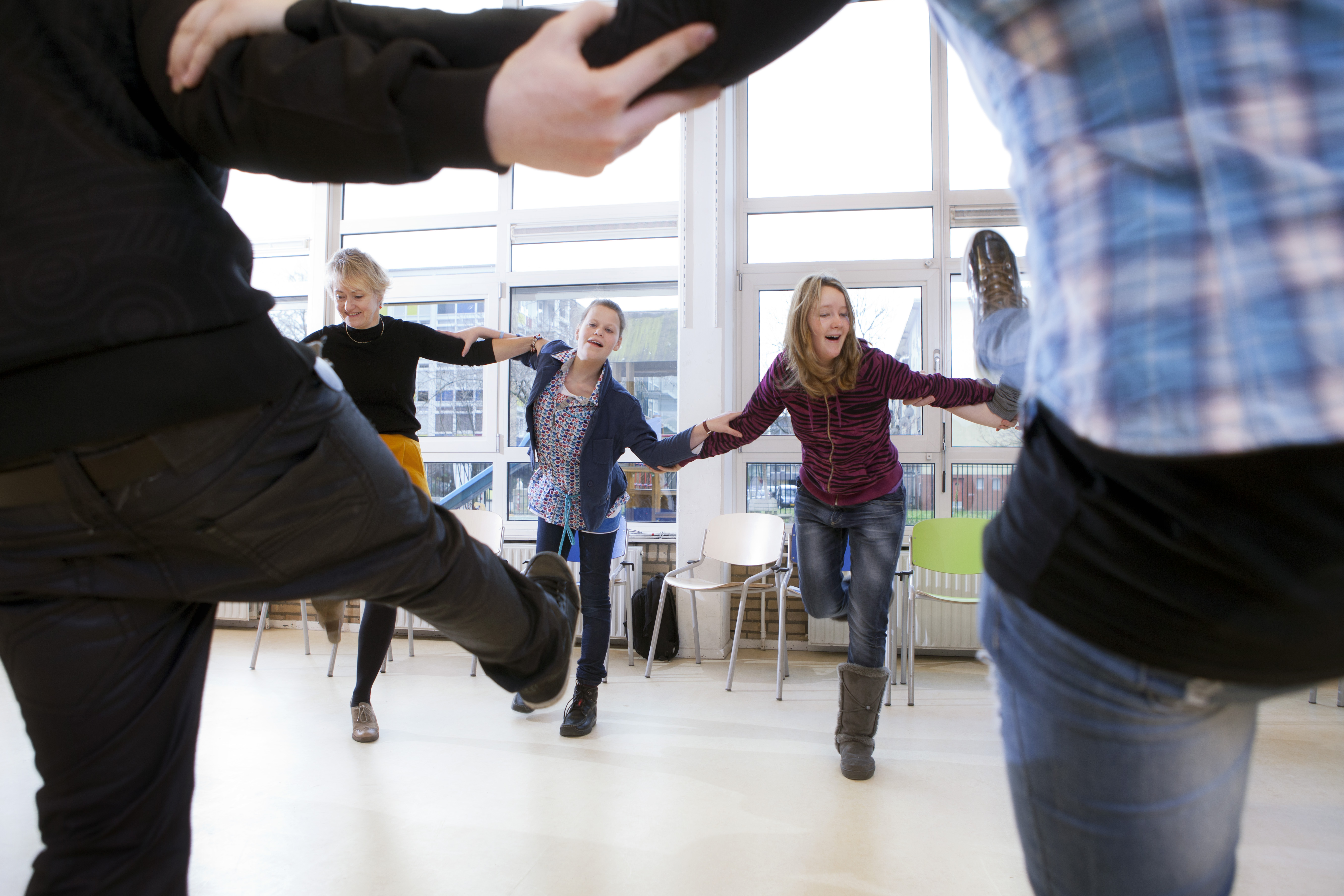 Leerlingen dansen samen in een kring. Leerlingen dansen samen in een kring.