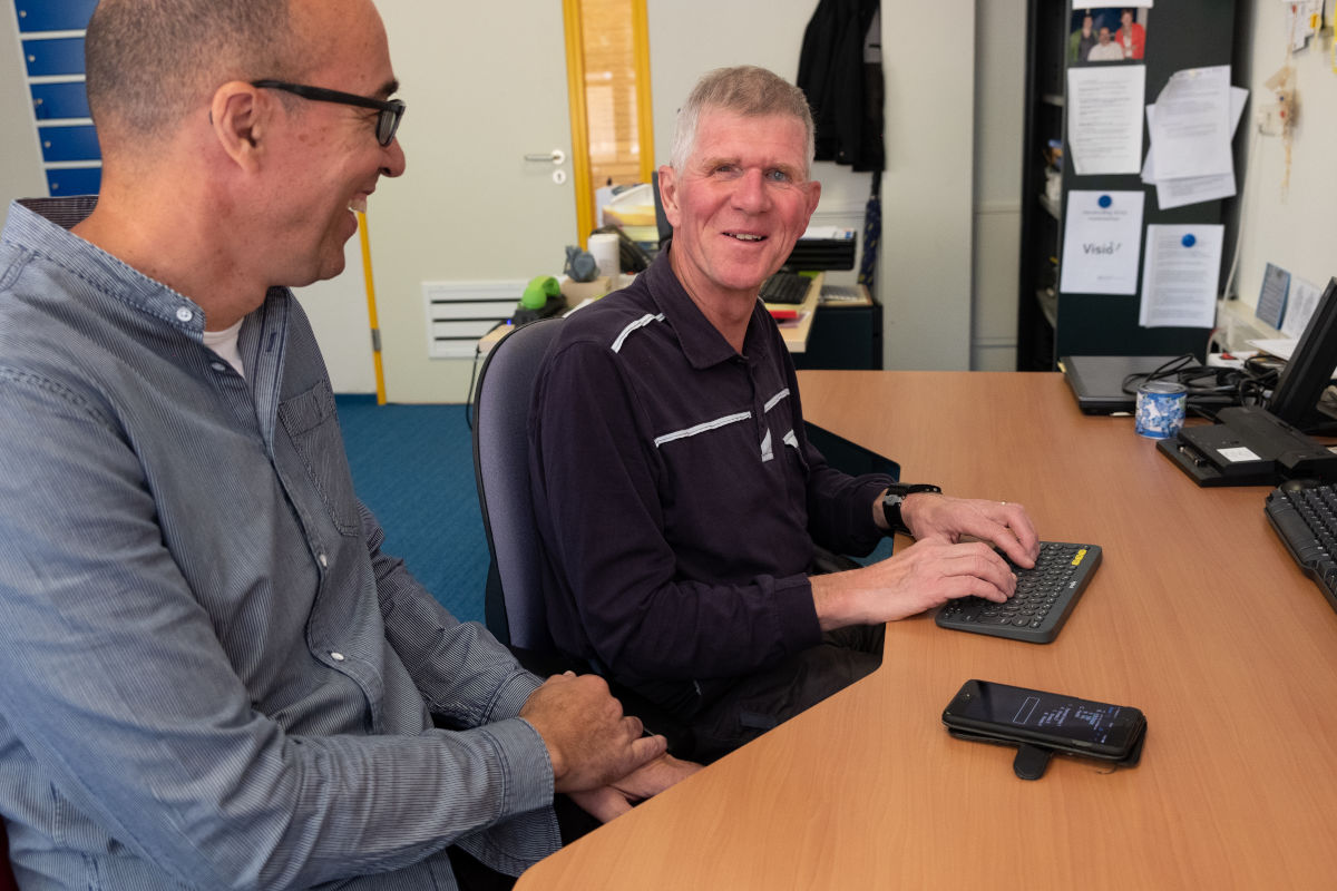 Cliënt krijgt training bij Visio Het Loo Erf en zit daarbij aan een bureau waarbij hij een brailletoetsenbord gebruikt Cliënt krijgt training bij Visio Het Loo Erf en zit daarbij aan een bureau waarbij hij een brailletoetsenbord gebruikt