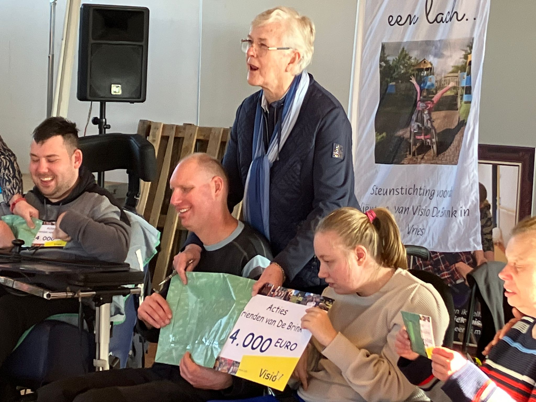 De cheque van 24000 euro wordt door de bewoners uit de envelop gehaald De cheque van 24000 euro wordt door de bewoners uit de envelop gehaald