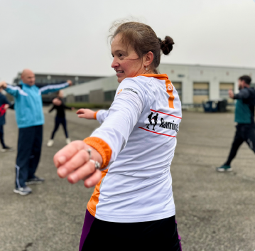 Vrouw in sportkleding doet oefeningen met haar armen.