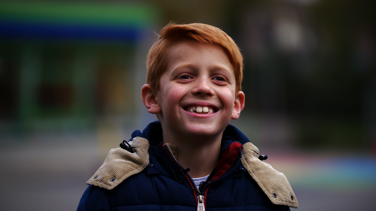 Kind met de aandoening CVI staat lachend op de foto Kind met de aandoening CVI staat lachend op de foto