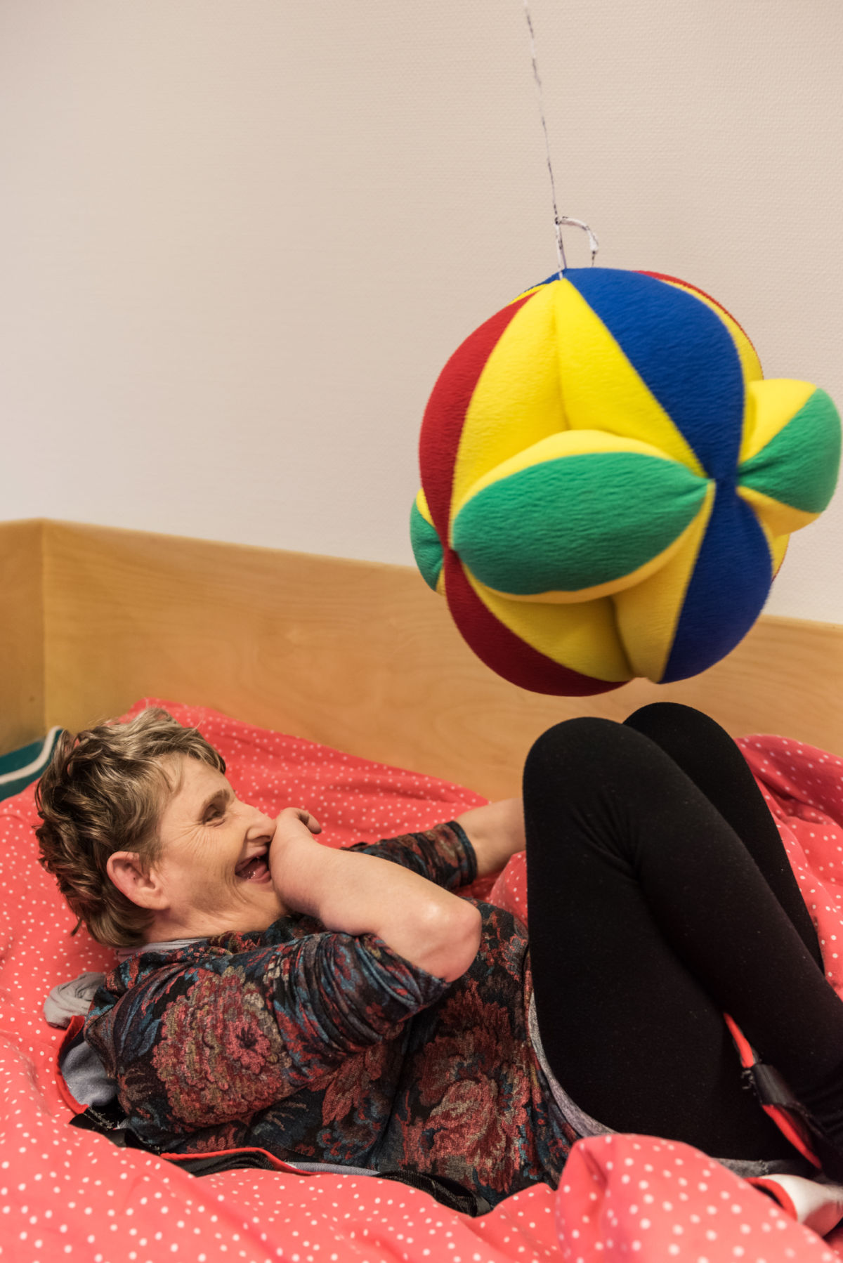 Vrouw speelt liggend in bed met een bal Vrouw speelt liggend in bed met een bal