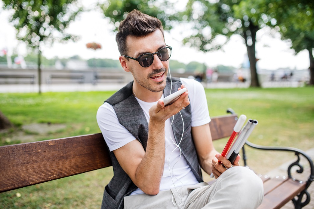 Jonge man op bankje luistert naar een podcast