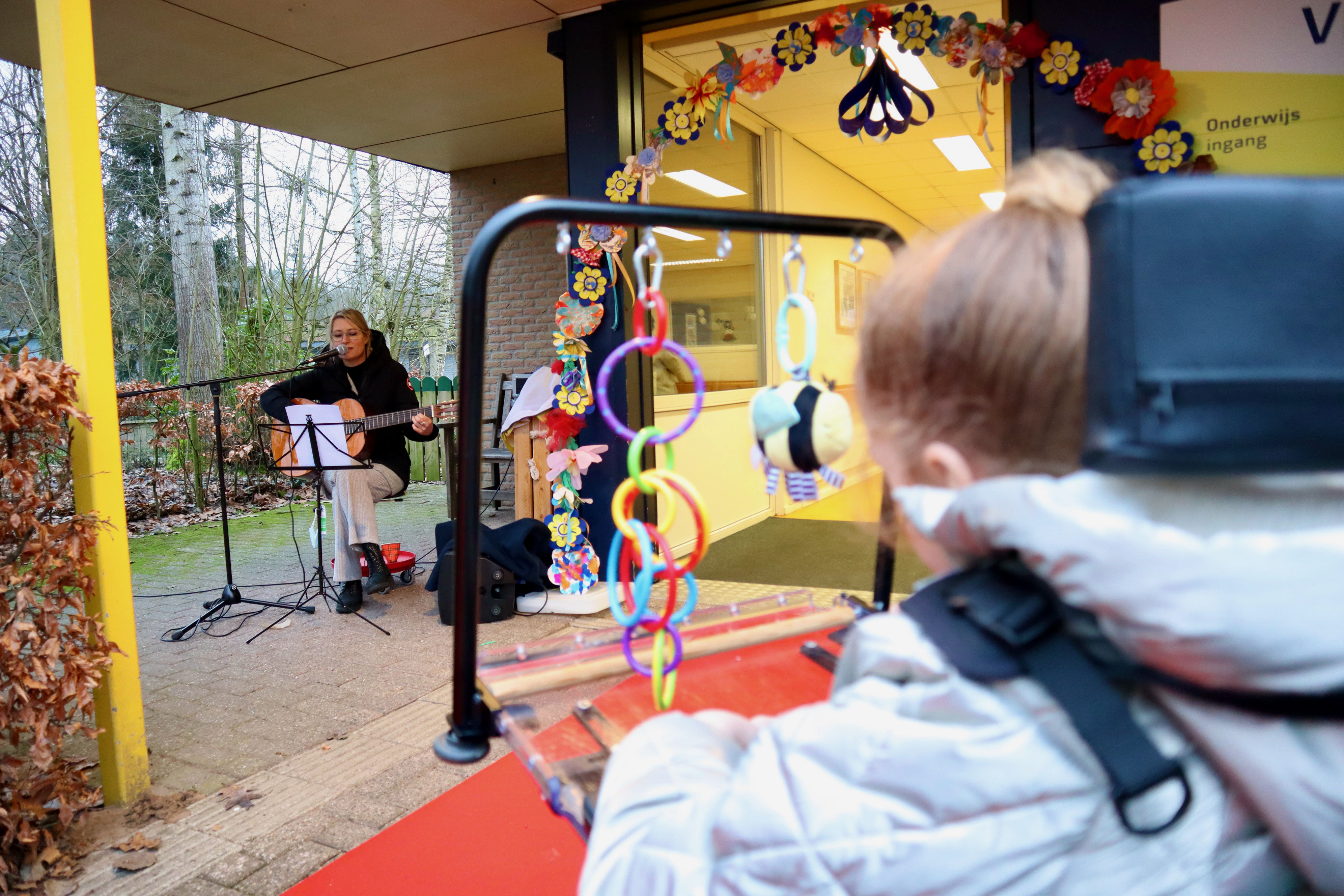 Kindje kijkt naar een docent die muziek maakt. Kindje kijkt naar een docent die muziek maakt.