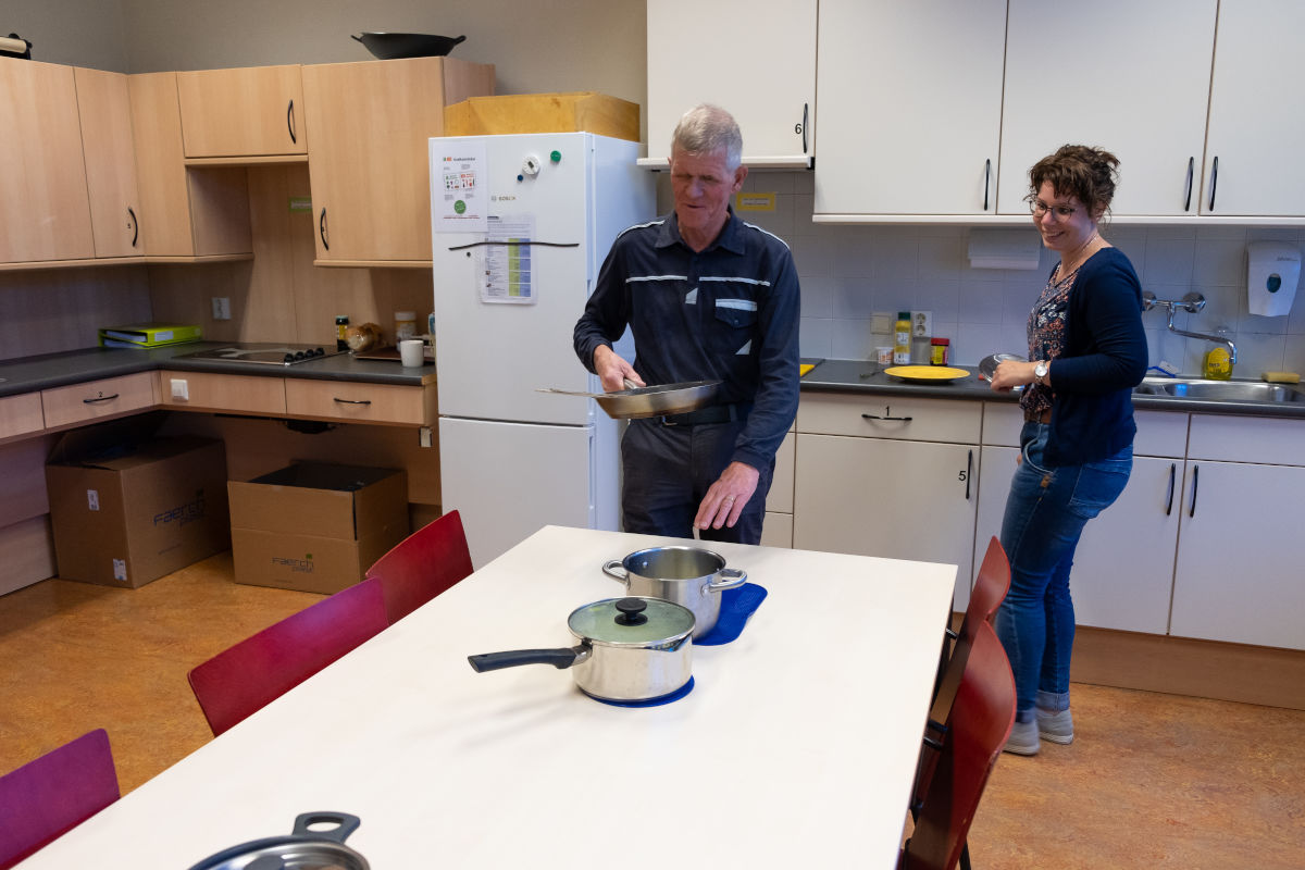 Cliënt oefent in een speciale, toegankelijke keuken van Visio Het Loo Erf met koken Cliënt oefent in een speciale, toegankelijke keuken van Visio Het Loo Erf met koken