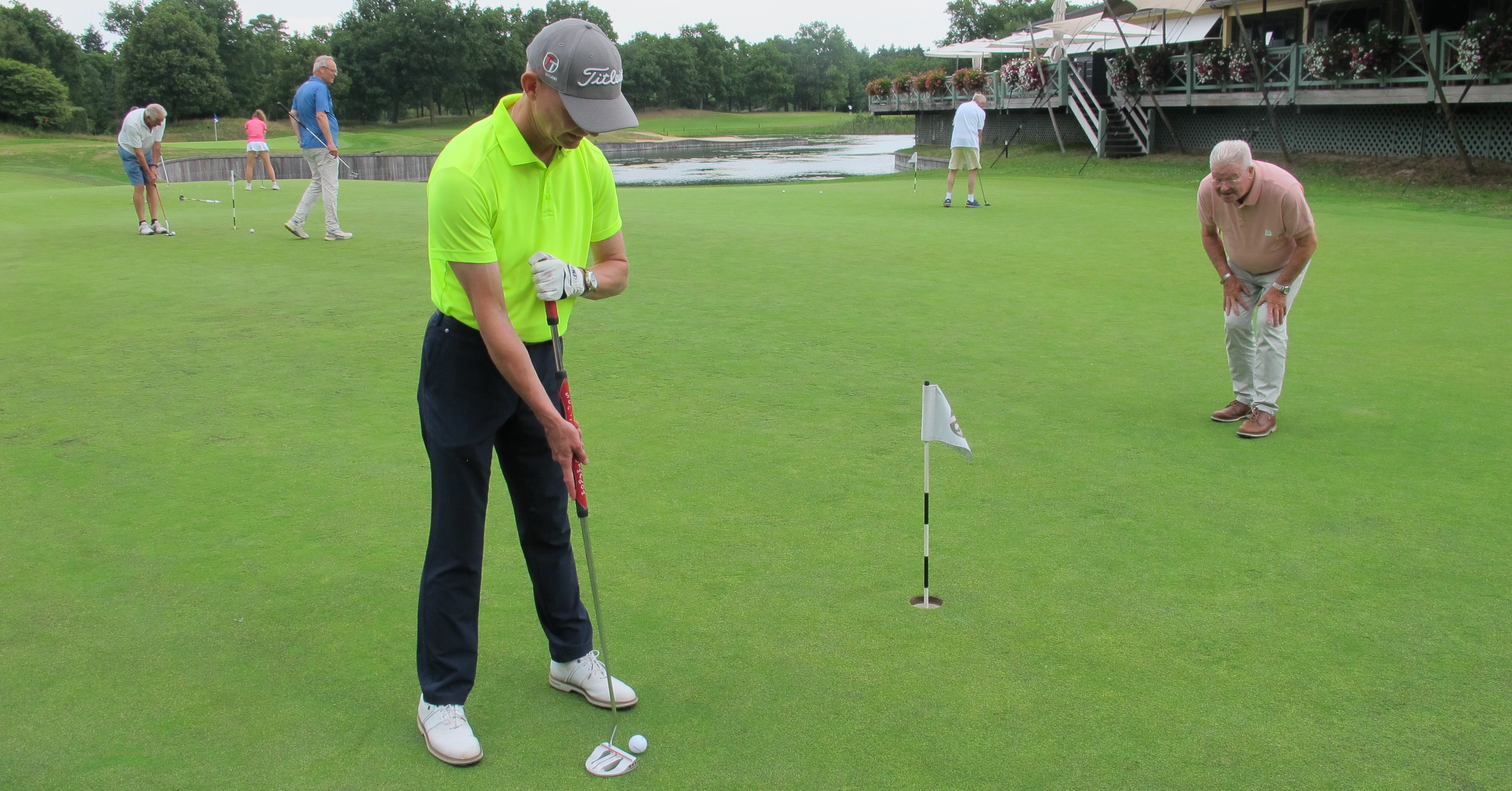 Ronald Boef staat op de golfbaan. Hij heeft een fel geel shirt aan en staat klaar om de golfbal in de hole te tikken. Ronald Boef staat op de golfbaan. Hij heeft een fel geel shirt aan en staat klaar om de golfbal in de hole te tikken.